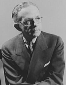 Walter White, a Black man, wearning a suit, tie, and glasses